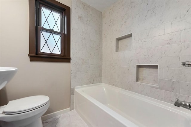 bathroom featuring a washtub and toilet