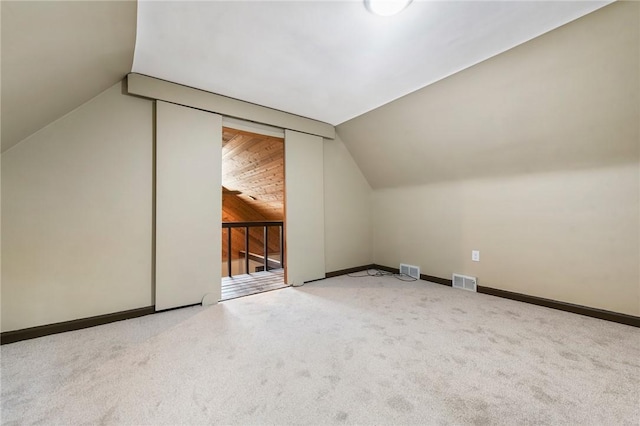 bonus room featuring vaulted ceiling and carpet flooring