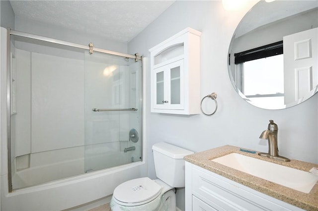 full bathroom featuring toilet, vanity, shower / bath combination with glass door, and a textured ceiling