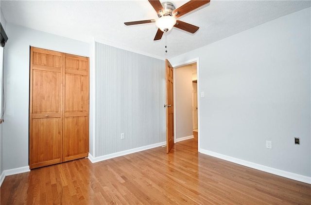 unfurnished bedroom featuring ceiling fan, light hardwood / wood-style floors, and a closet