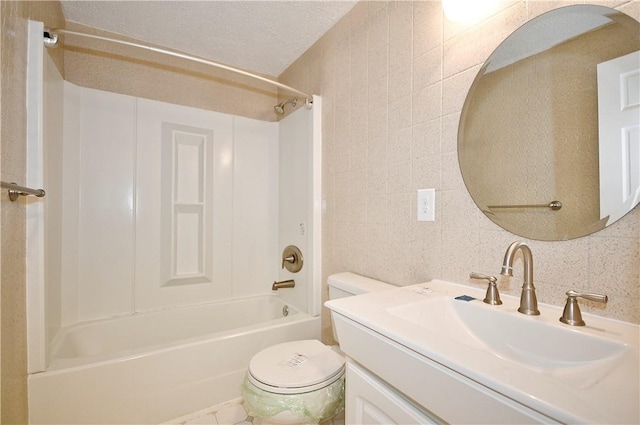 full bathroom with tile walls, vanity,  shower combination, toilet, and a textured ceiling