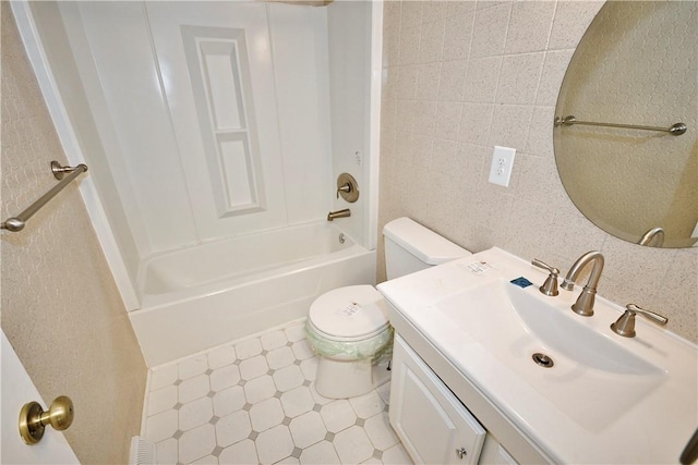 full bathroom featuring shower / washtub combination, tile walls, vanity, and toilet