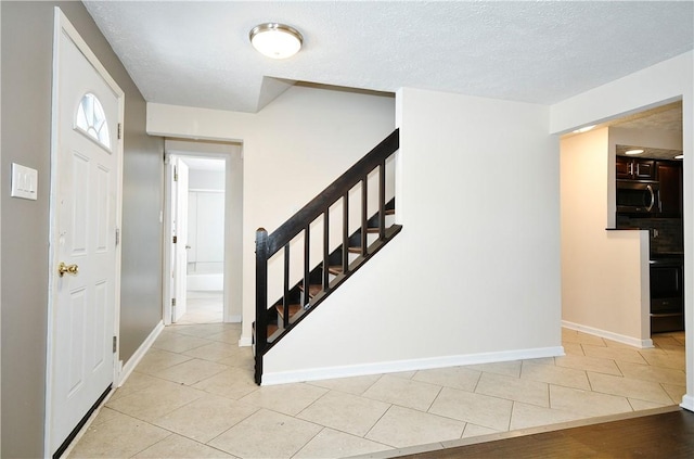 tiled entryway featuring a textured ceiling