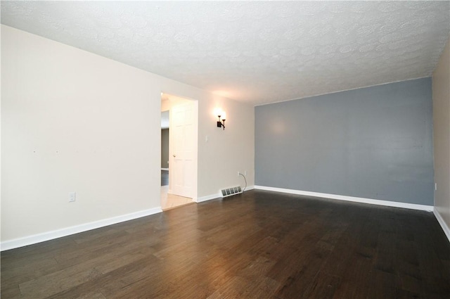 unfurnished room with dark hardwood / wood-style floors and a textured ceiling