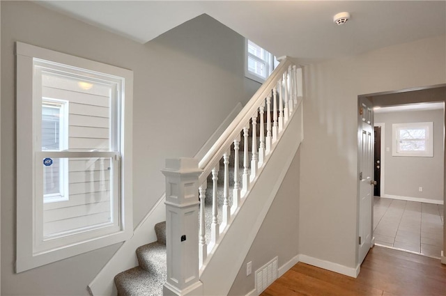 stairs featuring hardwood / wood-style flooring and plenty of natural light