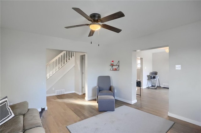 living area featuring hardwood / wood-style flooring and ceiling fan