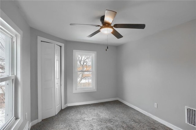 unfurnished bedroom featuring carpet floors, a closet, and ceiling fan