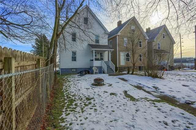 view of snow covered back of property