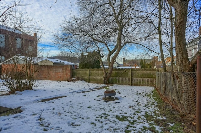 snowy yard featuring an outdoor fire pit