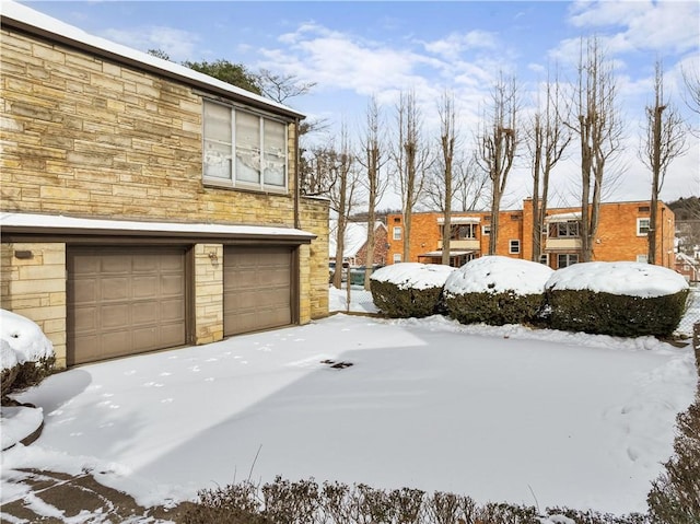 yard layered in snow with a garage