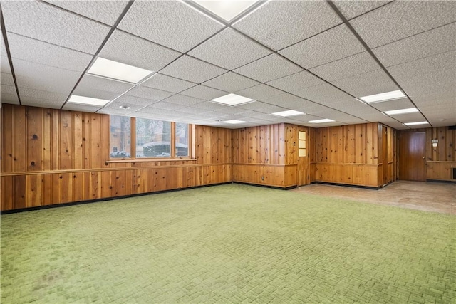 basement with wooden walls and a drop ceiling