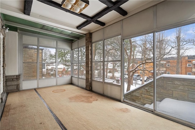 unfurnished sunroom featuring beamed ceiling and coffered ceiling