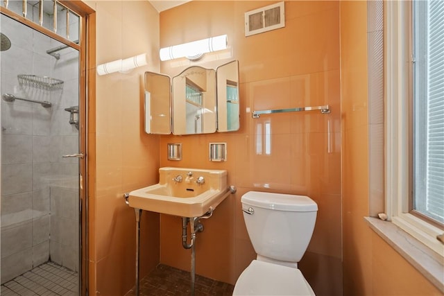 bathroom with toilet, an enclosed shower, and sink