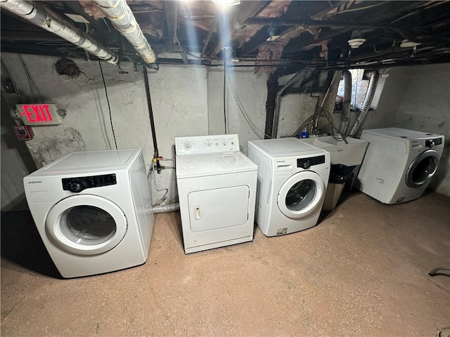 clothes washing area with independent washer and dryer and sink