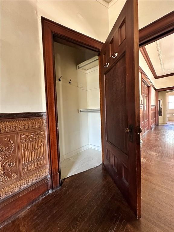 hall with hardwood / wood-style flooring and ornamental molding