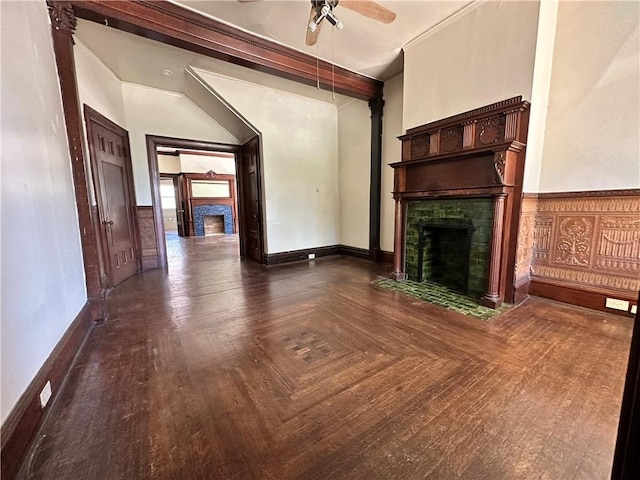 unfurnished living room with crown molding, ceiling fan, dark parquet flooring, and a tile fireplace