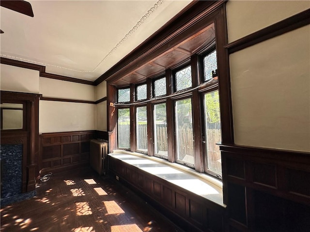 interior space with crown molding, radiator heating unit, and dark hardwood / wood-style flooring