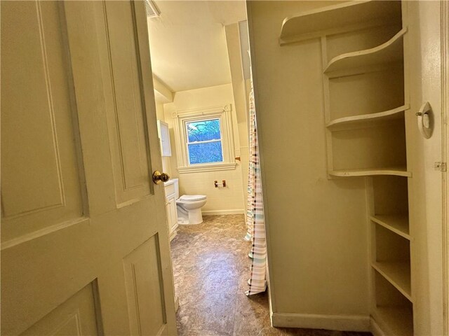 bathroom featuring tile walls and toilet