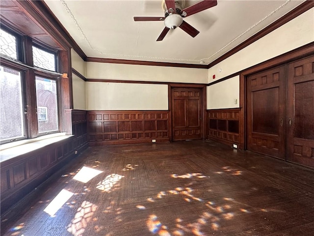 empty room featuring ceiling fan and crown molding