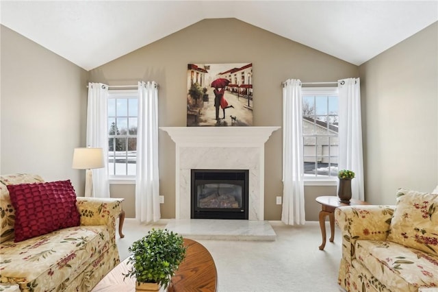 carpeted living room with lofted ceiling and a high end fireplace