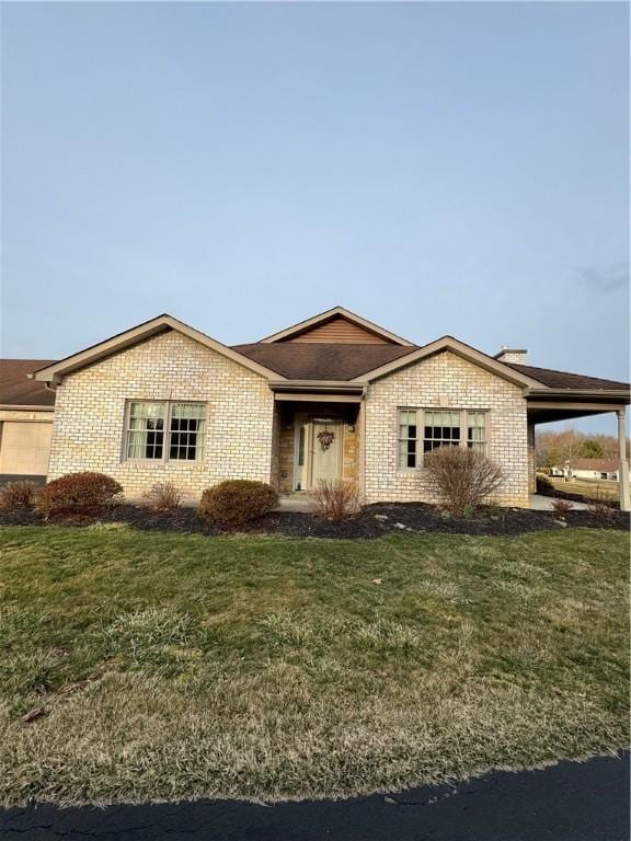 ranch-style house with brick siding and a front yard