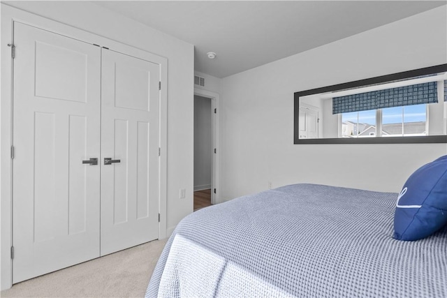 bedroom featuring light colored carpet and a closet