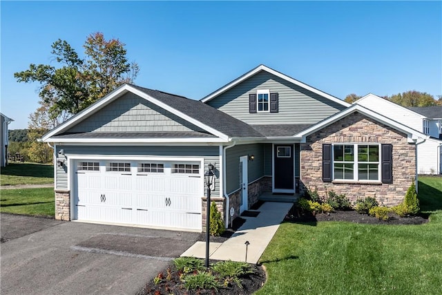 craftsman inspired home with a garage and a front lawn