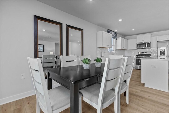 dining area featuring sink and light hardwood / wood-style floors