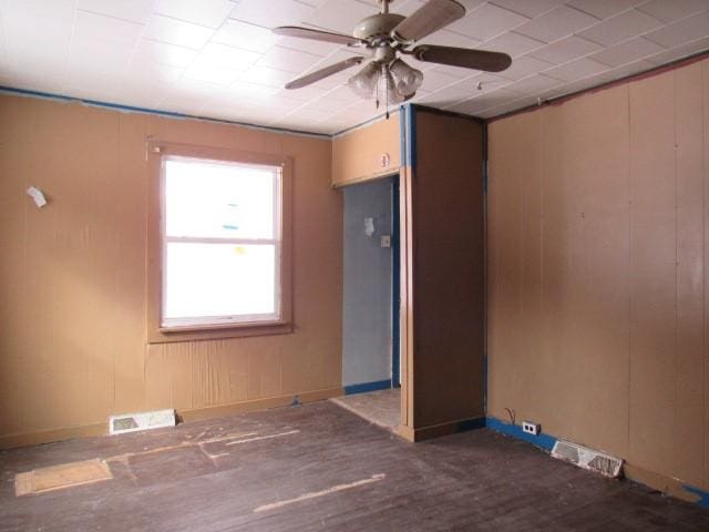 unfurnished room with dark wood-type flooring and ceiling fan