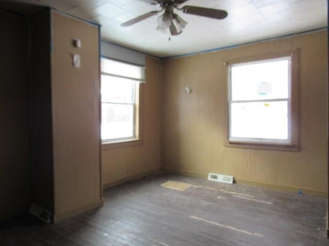 empty room with ceiling fan and hardwood / wood-style floors