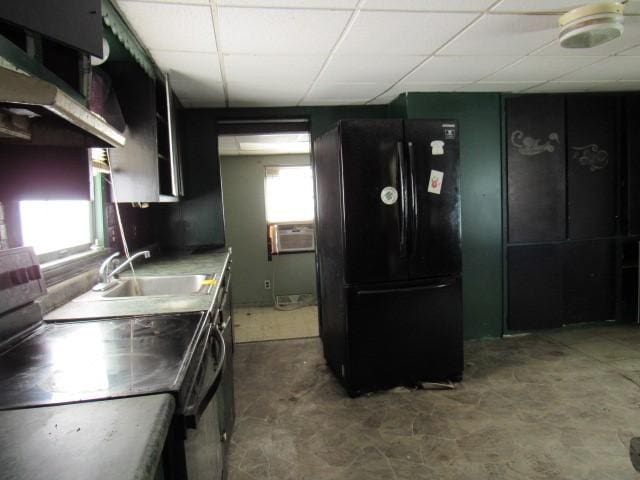 kitchen with sink, a paneled ceiling, black refrigerator, cooling unit, and range with electric cooktop