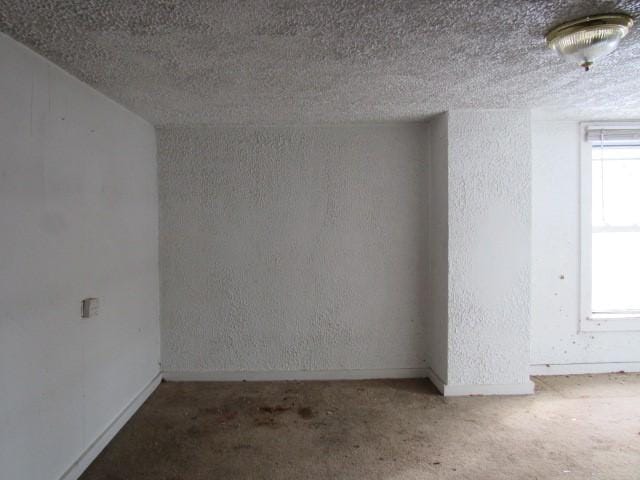 unfurnished room with carpet floors and a textured ceiling