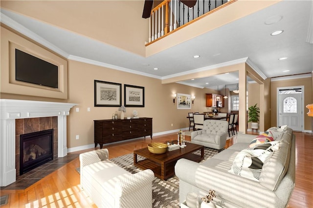 living room with ornamental molding, dark wood-type flooring, and a tile fireplace