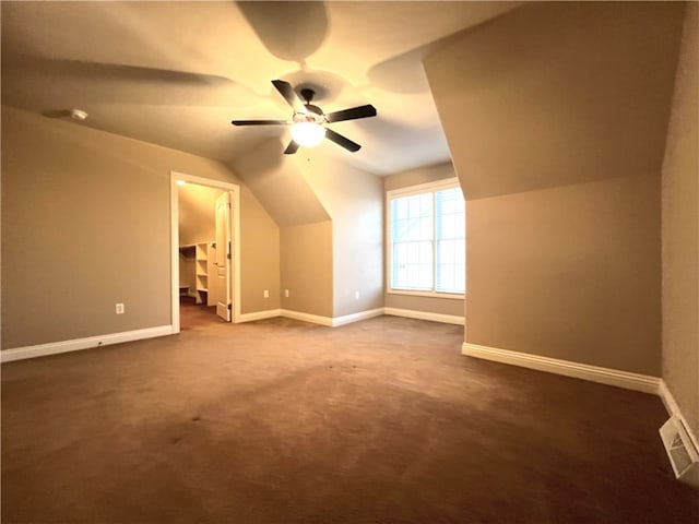 bonus room with lofted ceiling, dark carpet, and ceiling fan