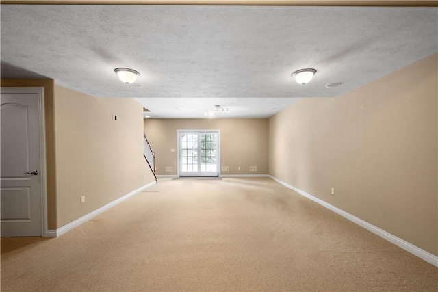 unfurnished room featuring light colored carpet and a textured ceiling