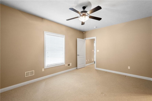 carpeted spare room featuring ceiling fan