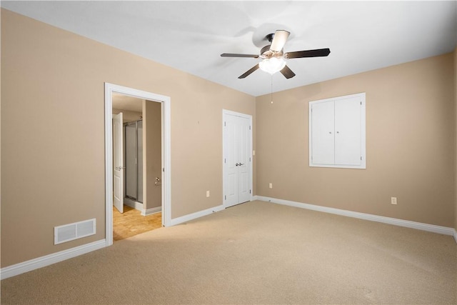 unfurnished bedroom featuring ensuite bathroom, light carpet, and ceiling fan