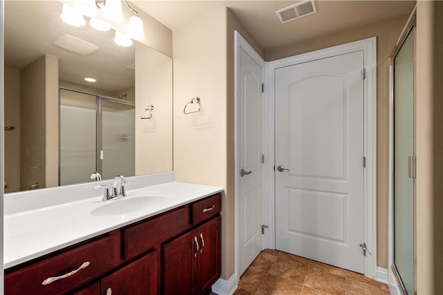 bathroom with vanity and a shower with door