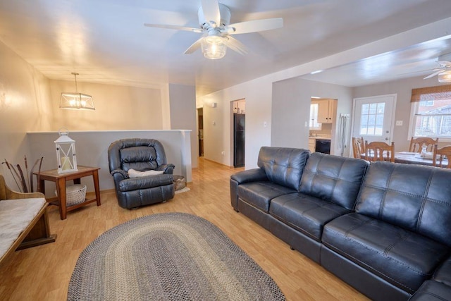 living room with ceiling fan and light wood-type flooring