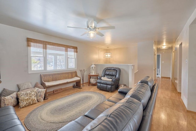 living room featuring light hardwood / wood-style flooring and ceiling fan