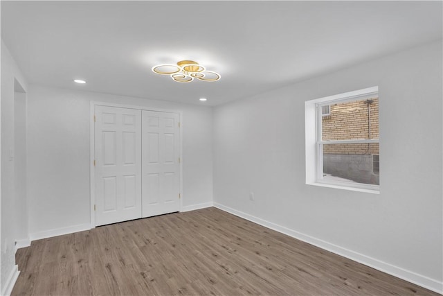 unfurnished bedroom with light hardwood / wood-style floors and a closet