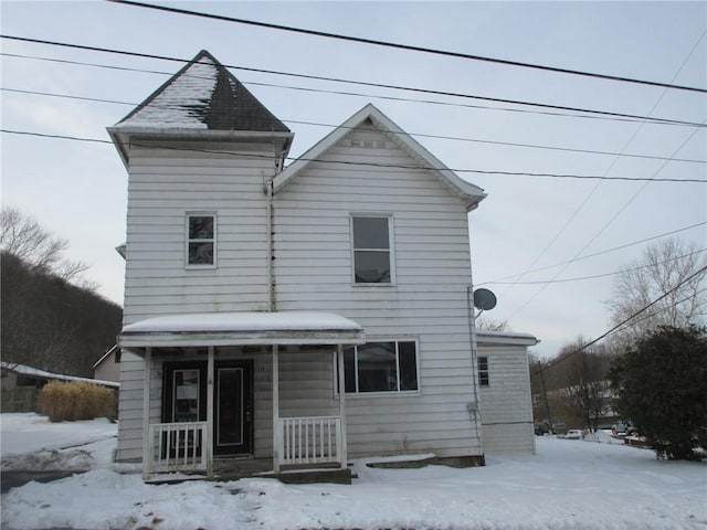 view of snow covered rear of property