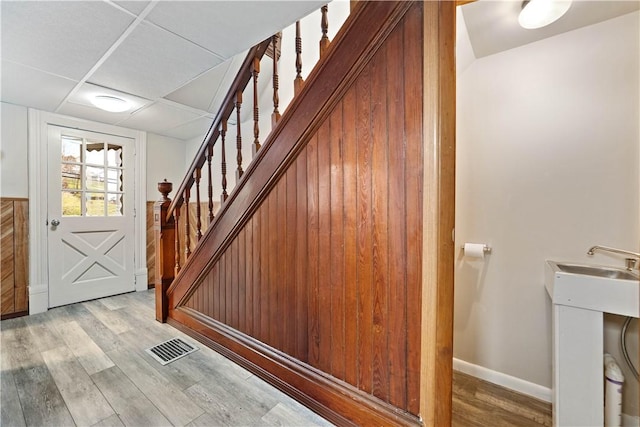 staircase featuring hardwood / wood-style flooring and a paneled ceiling