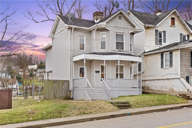 view of front of property with a porch and a yard