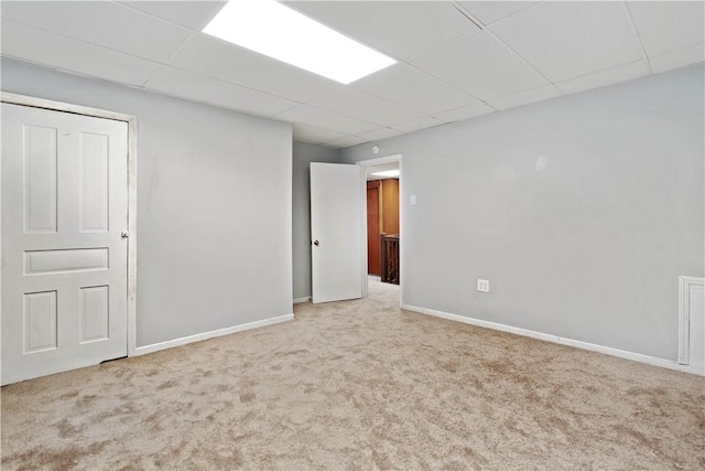 unfurnished room featuring light colored carpet and a paneled ceiling