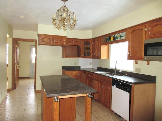 kitchen featuring sink, light tile patterned floors, an inviting chandelier, a center island, and white dishwasher