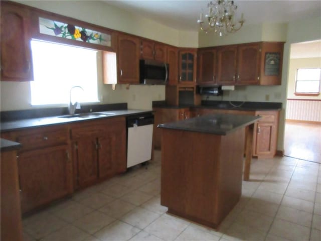 kitchen featuring sink, dishwasher, a kitchen island, a notable chandelier, and light tile patterned flooring