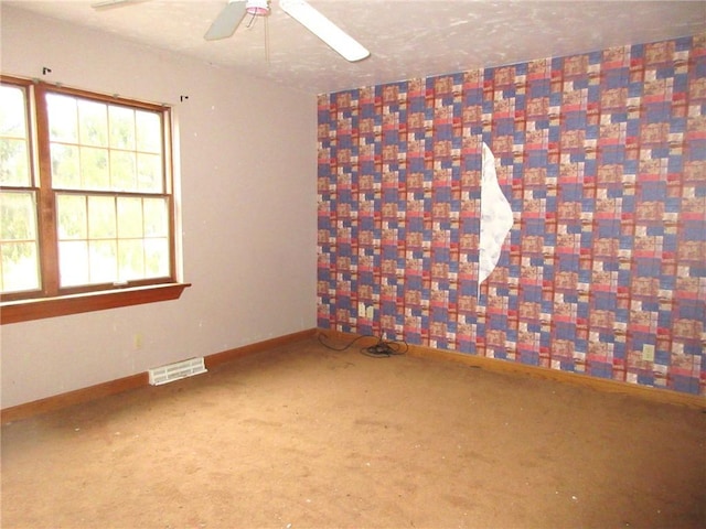 empty room with ceiling fan and carpet flooring