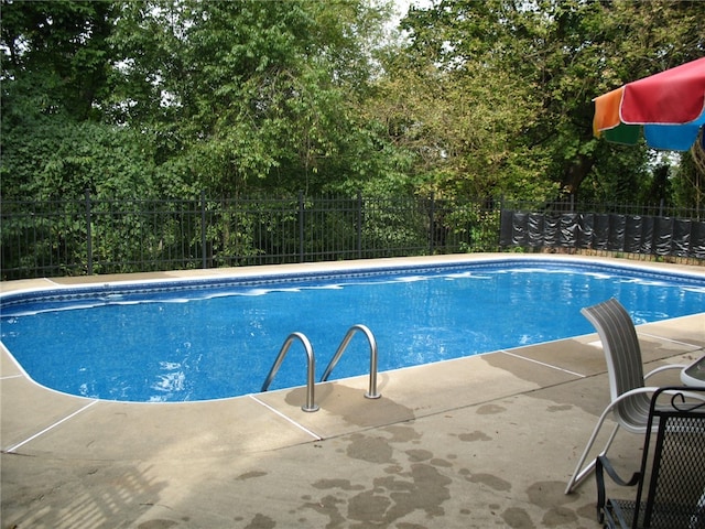 view of swimming pool featuring a patio, fence, and a fenced in pool