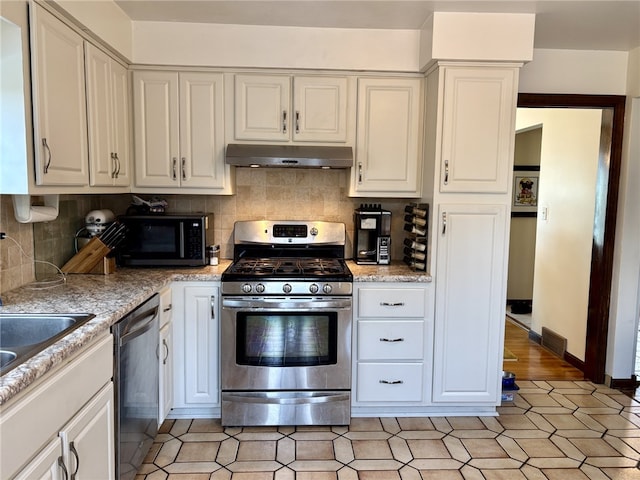 kitchen with decorative backsplash, stainless steel appliances, under cabinet range hood, white cabinetry, and a sink